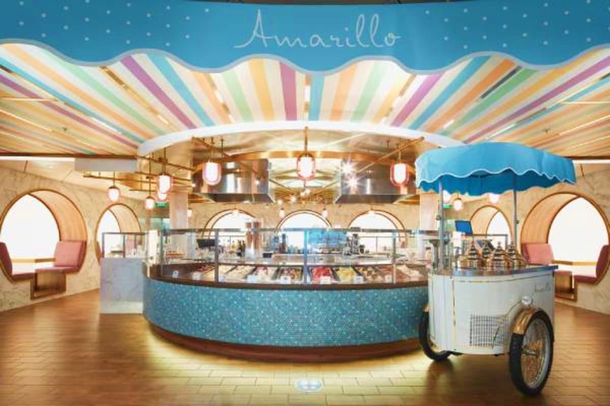 Amarillo ice cream parlor interior on Costa Smeralda cruise ship with colorful striped ceiling, curved service counter, and v